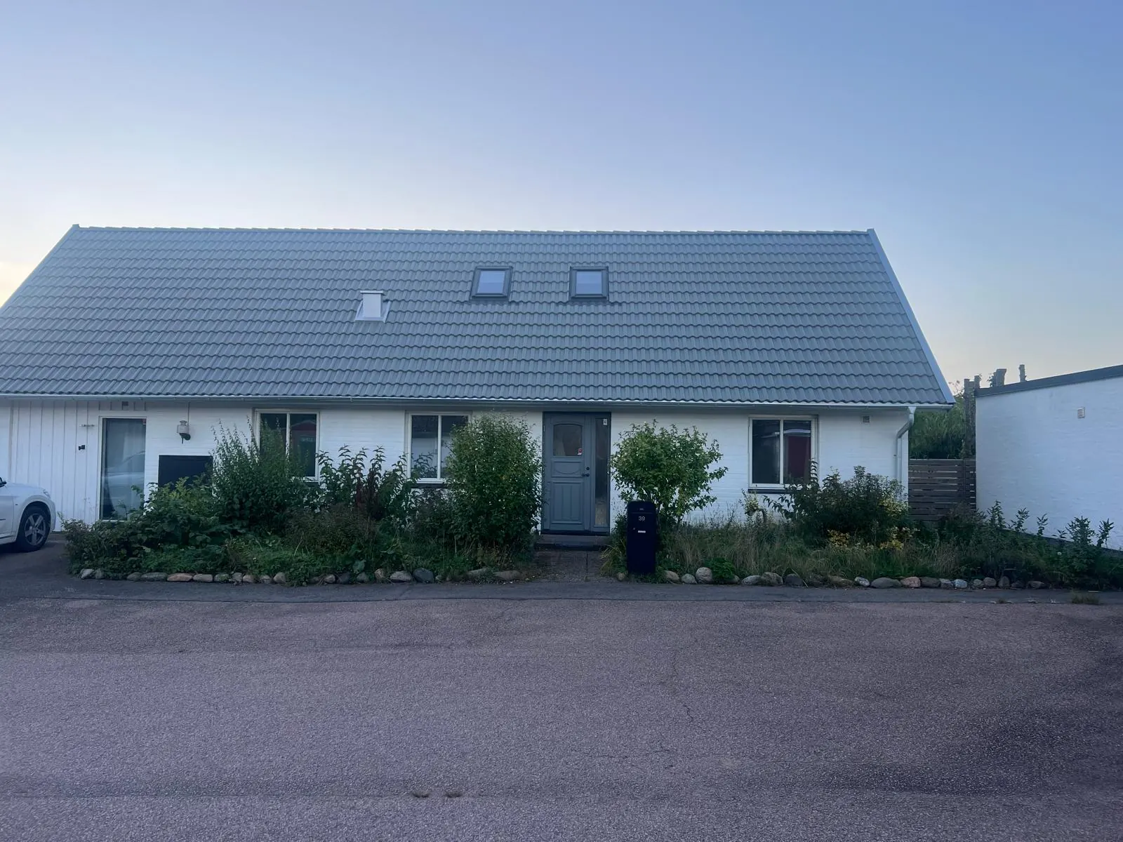 Vitt hus med nytt ljust pann tak, takbyte klart och övertämnat av E.K Tak & Tätskikt